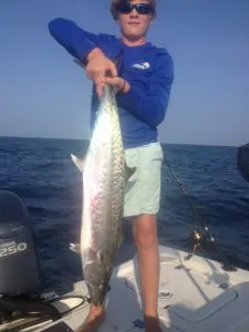 young man holding king mackerel by the tail
