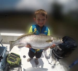 toddler holding very large fish