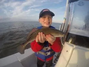 Smiling boy holding speckled trout