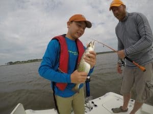 boy holding and looking at a speckled trout