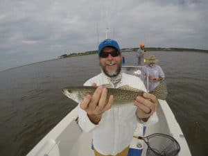 man holding speckled trout