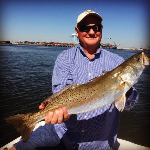 man holding big speckled trout