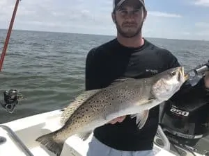 man holding trophy sized speckled trout