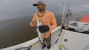 mann holding big speckled trout