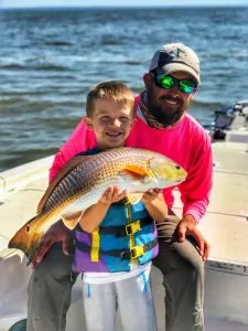 captain patric with his son holding redfish