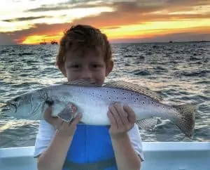 child holding big speckled trout