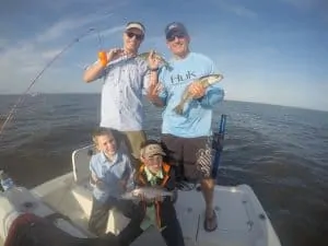 family holding speckled trout