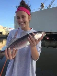 young lady holding speckled trout