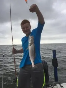 boy holding up speckled trout