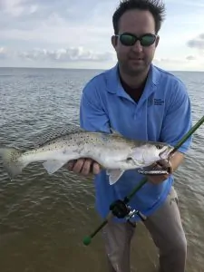 man holding speckled trout