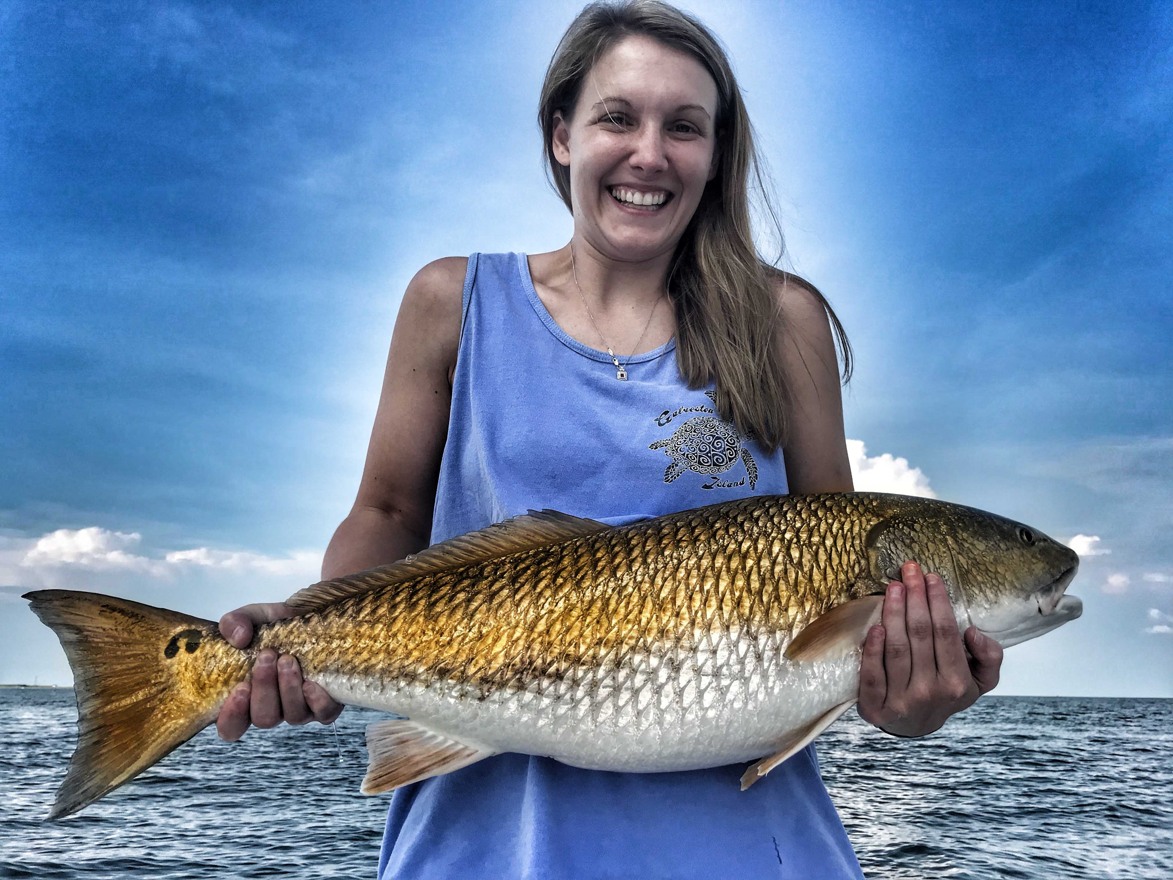 Woman-holding-bull-redfish-on-boat-in-mobile-bay