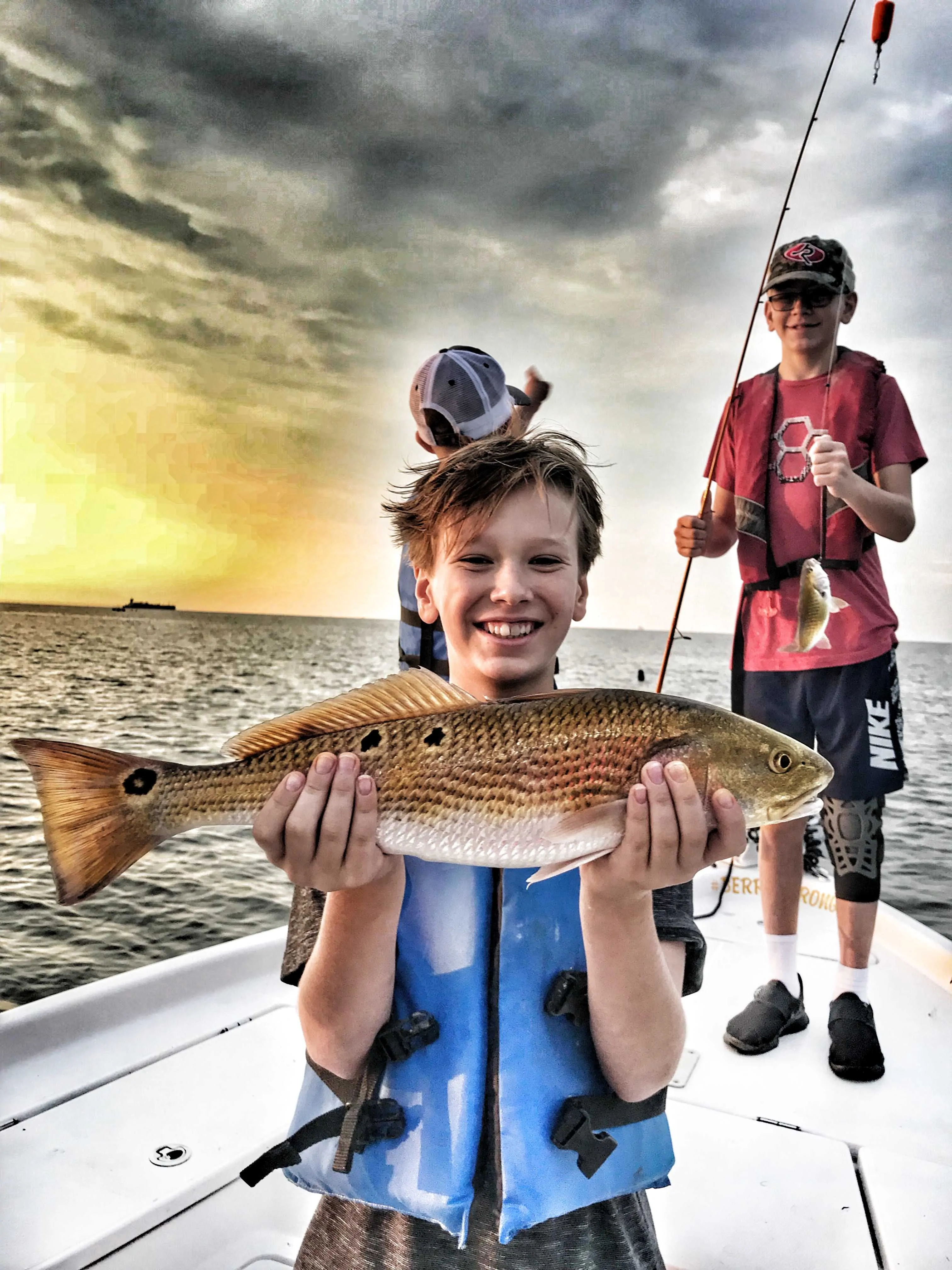teenager-smiling-holding-slot-redfish