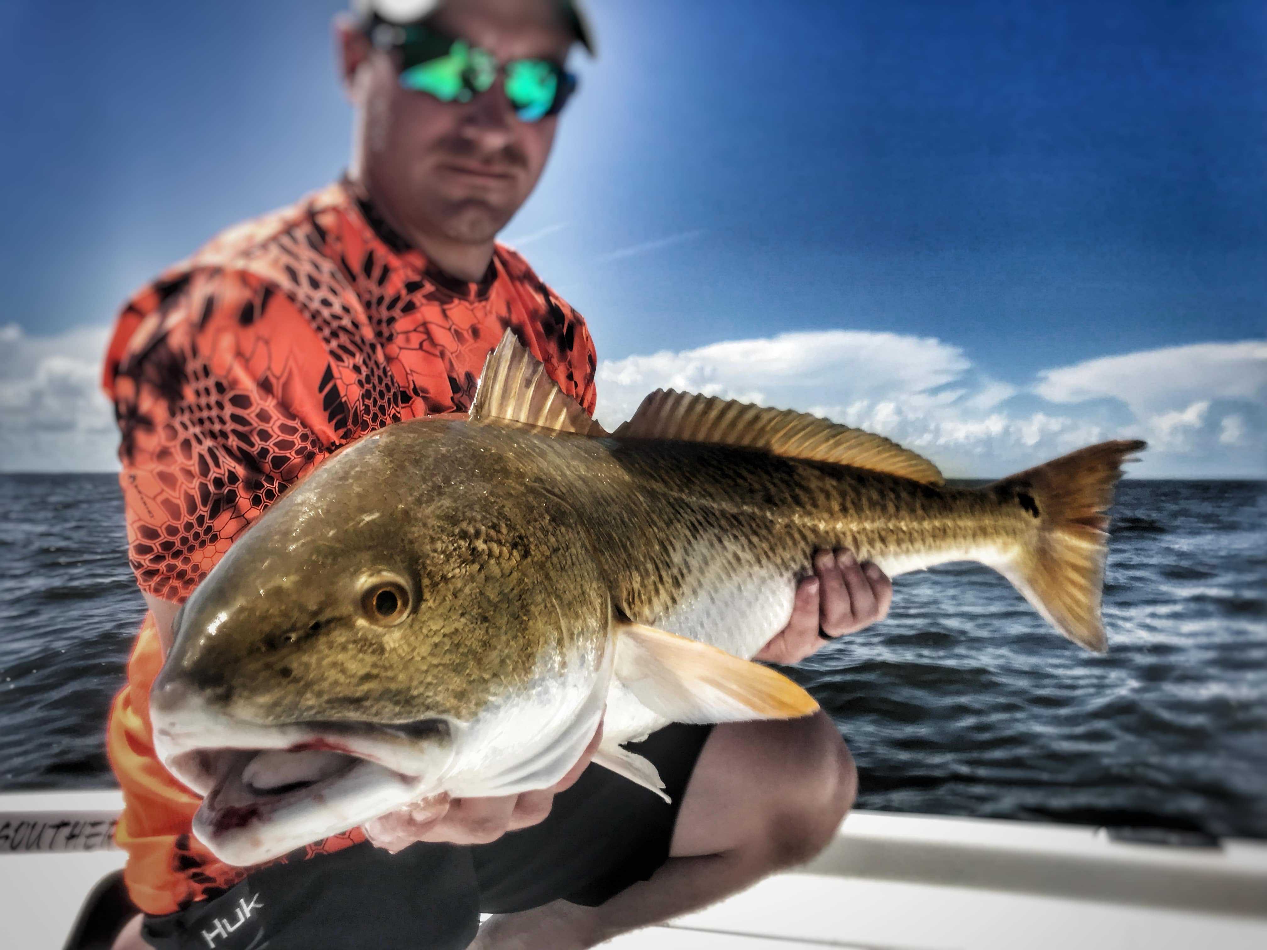 man-holding-big-bull-redfish