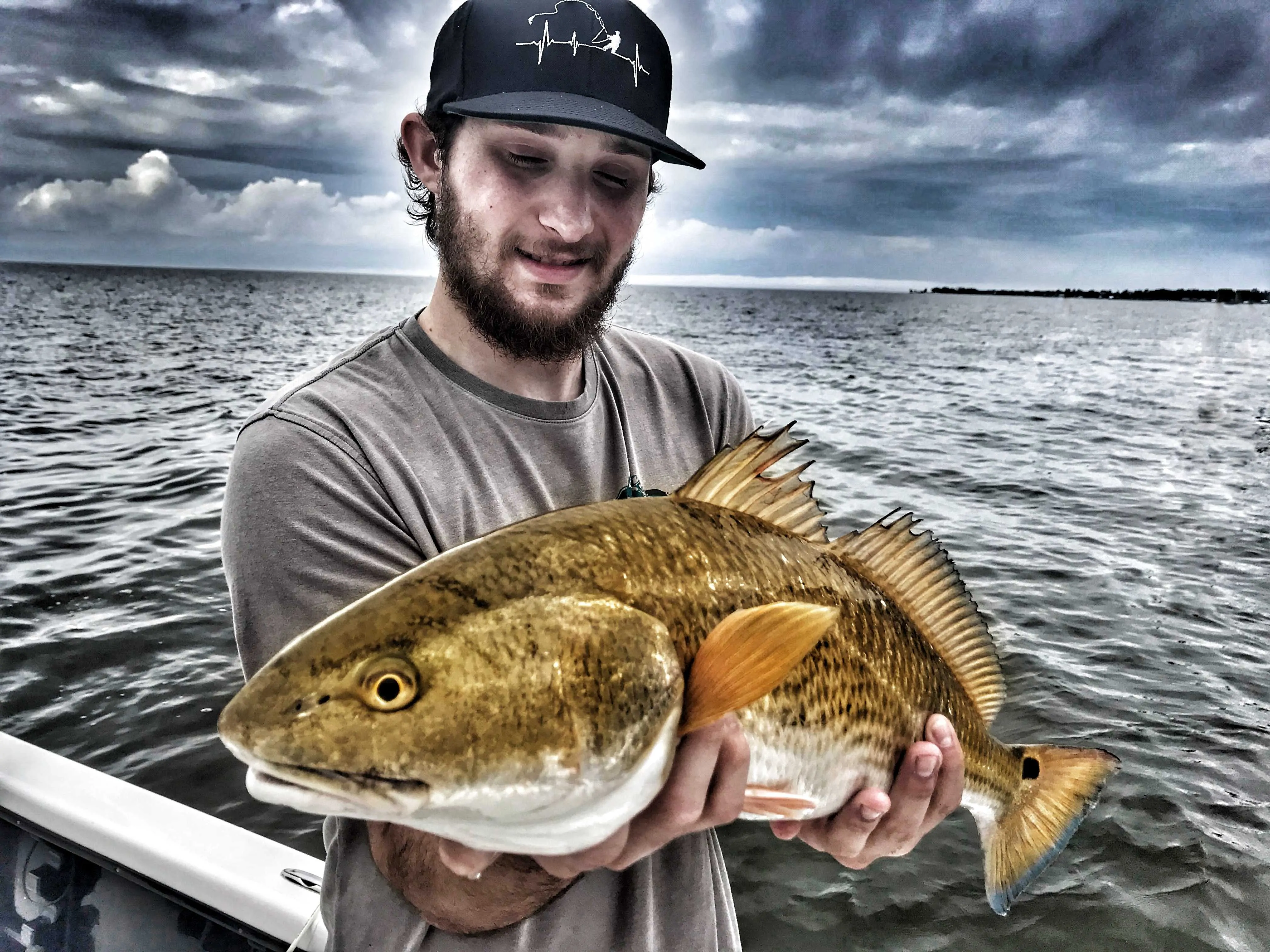 man-holding-redfish-while-on-the-boat-with-captain-patric-garmeson