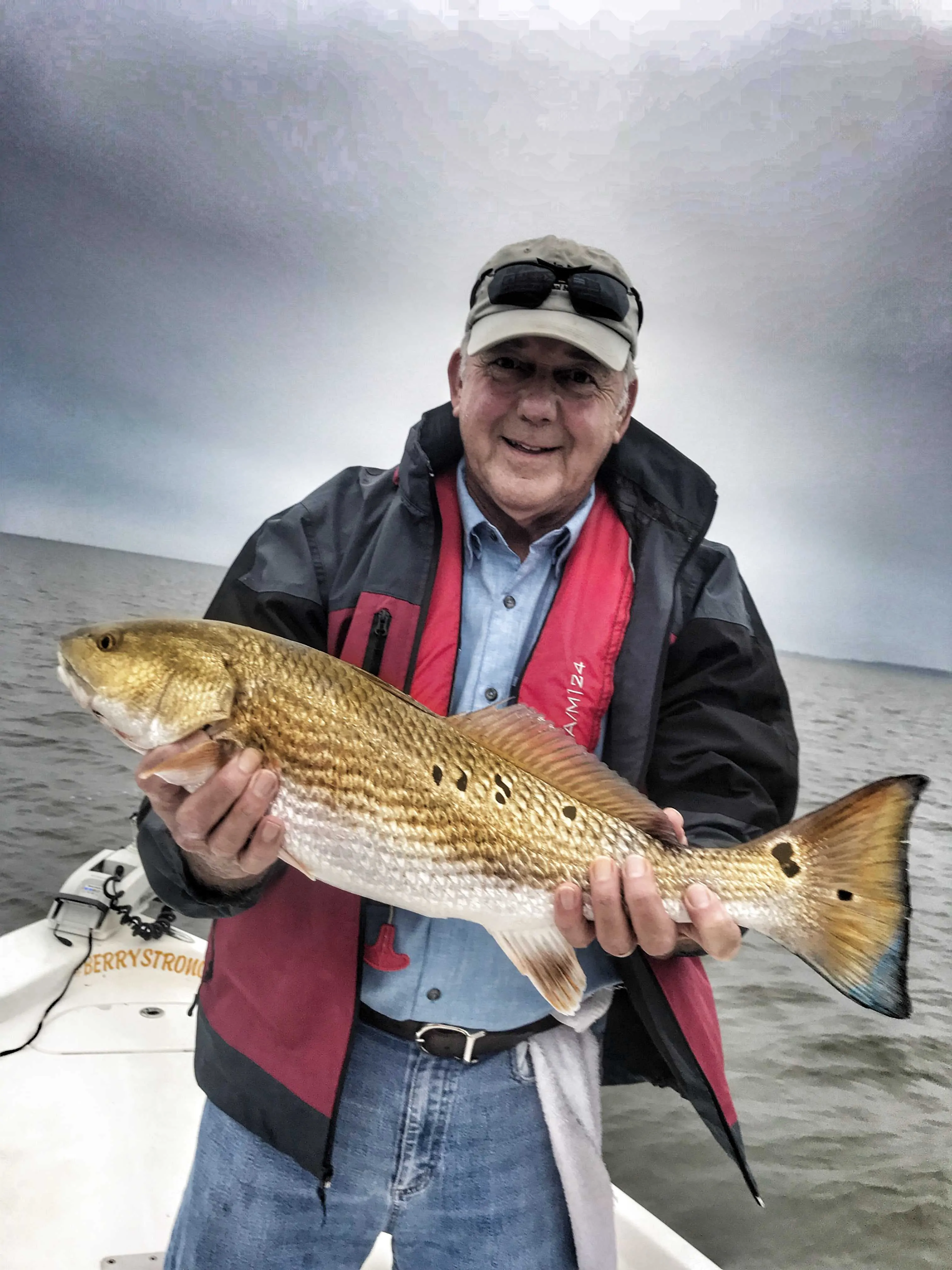 man-holding-redfish-while-fishing-with-captain-patric-garmeson
