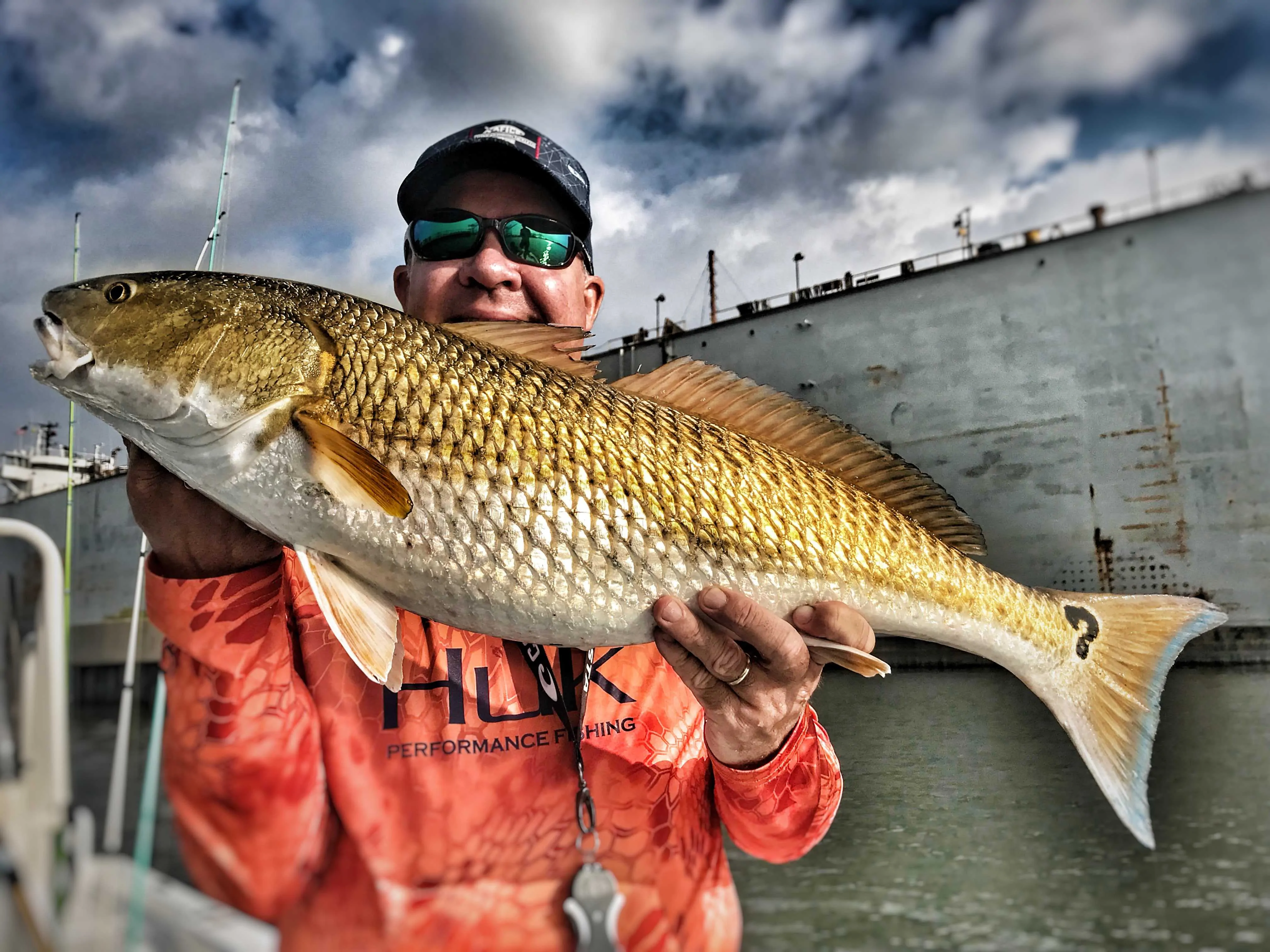 man-holding-redfish-with-question-mark-spot-on-tail