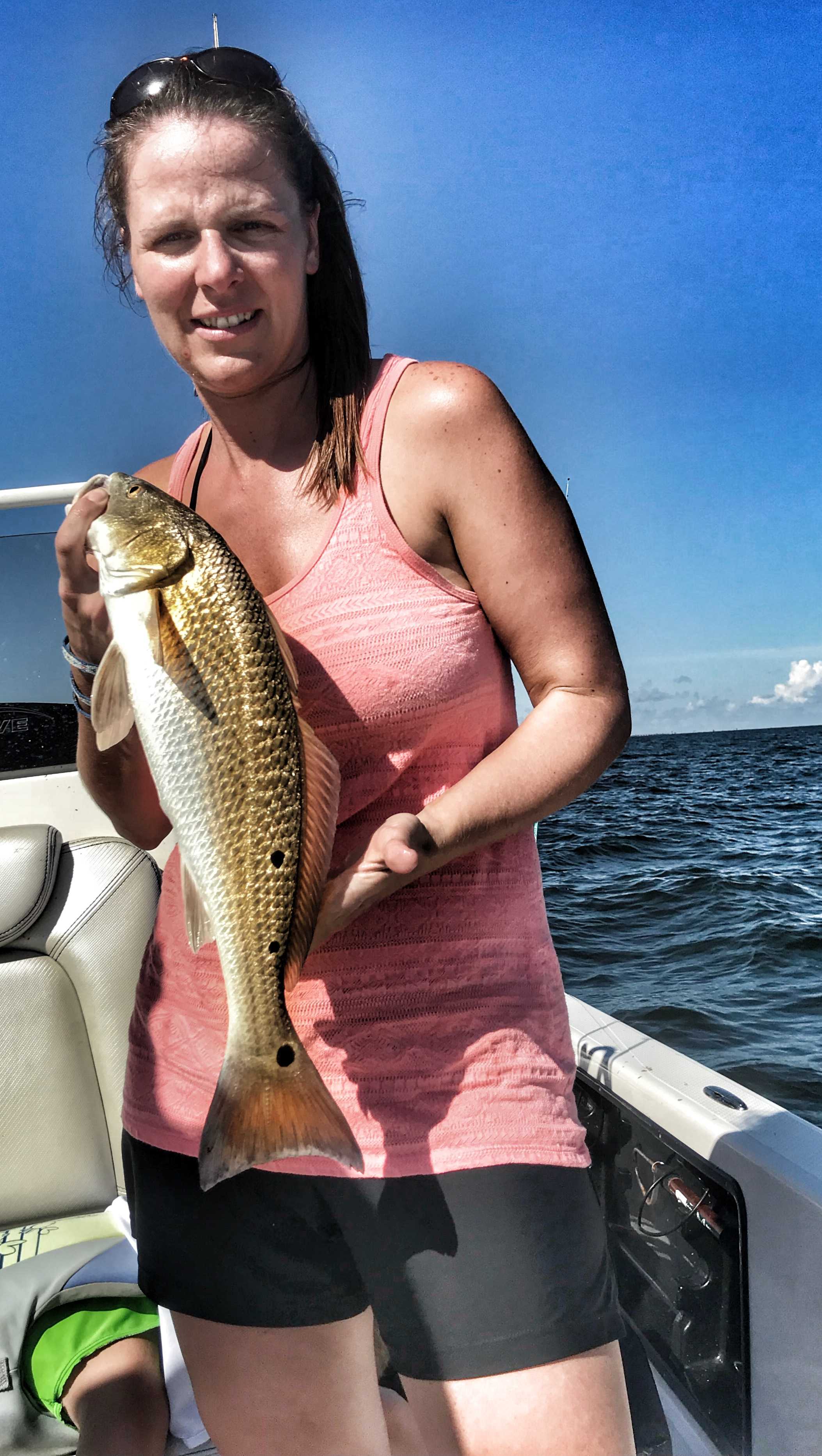 lady-holding-redfish-with-three-spots-on-one-side