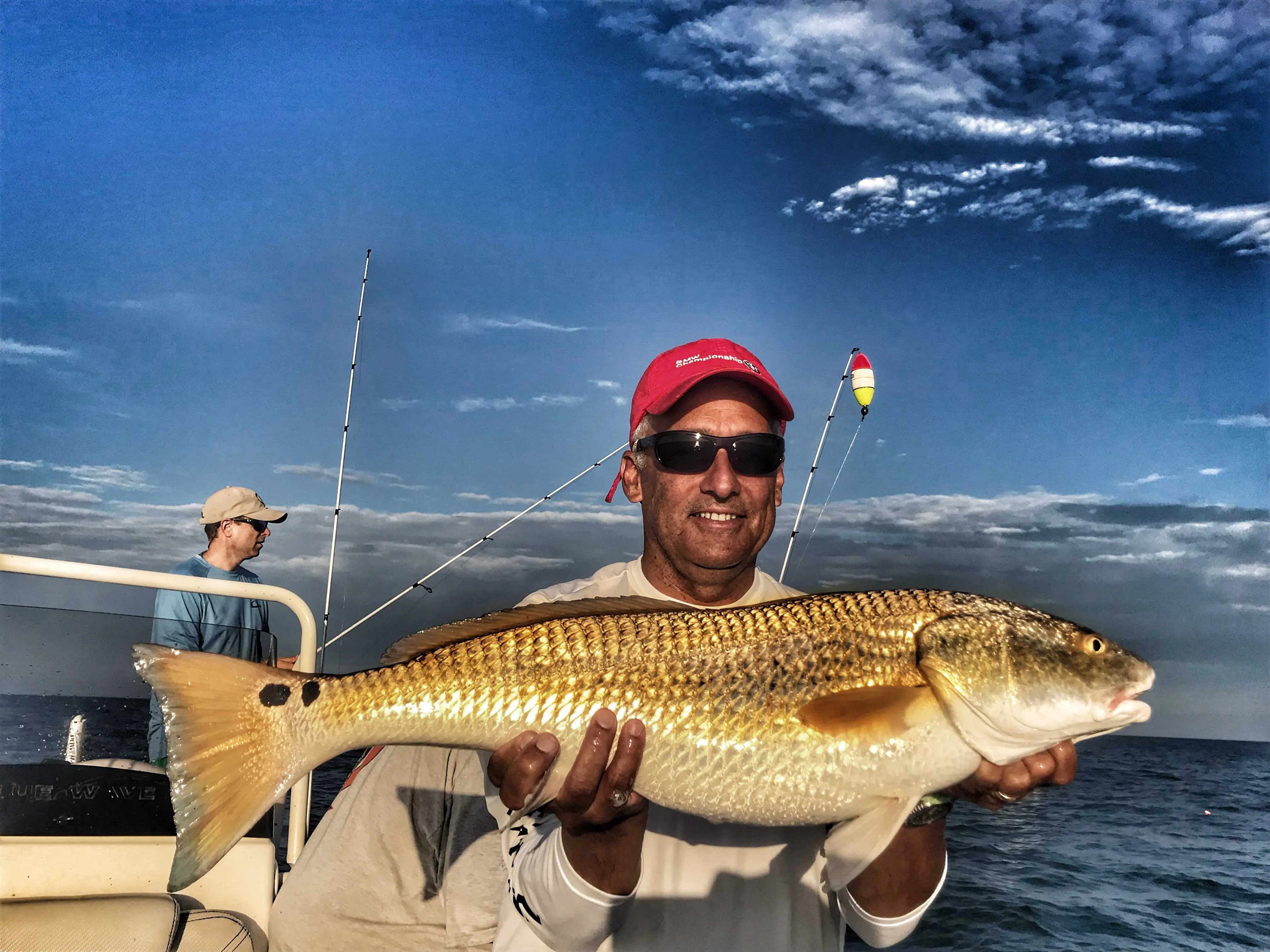 man-holding-two-spotted-bull-redfish