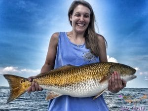 Dauphin island fishing charter lady holding large redfish