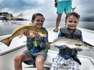 Mobile Alabama fishing charter two kids holding fish