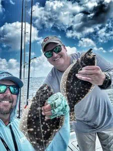 captain patric and guest holding flounder caught on slick lures