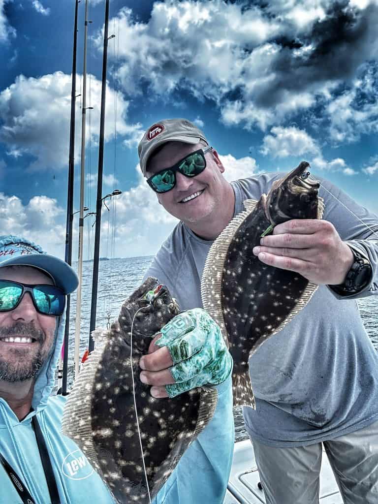 captain patric and guest holding flounder caught on slick lures